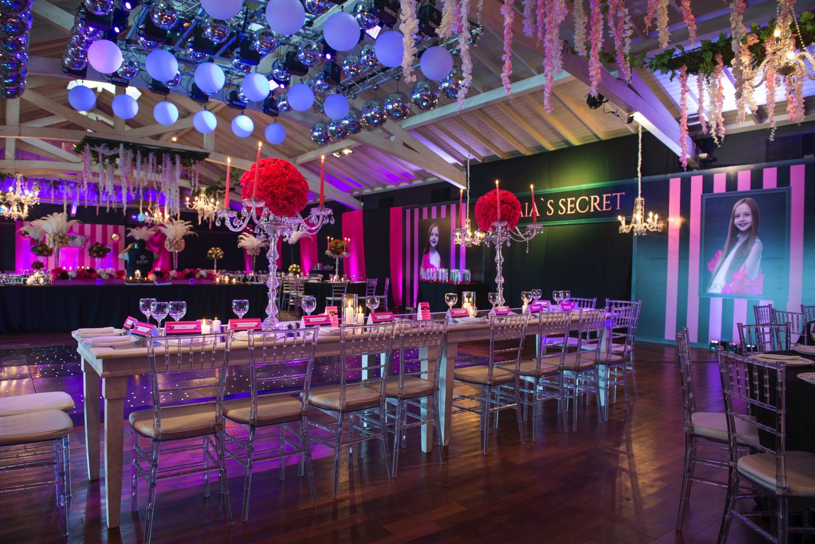 Salón con mesas largas y luces rosas